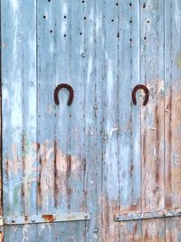 Rusty horseshoes mounted on wooden wall