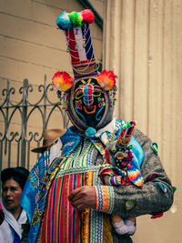 Portrait of man standing against multi colored wall