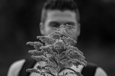 Young man holing plant outdoors