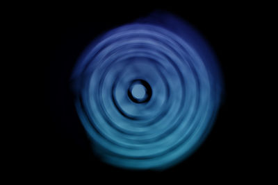 Close-up of blue light over black background