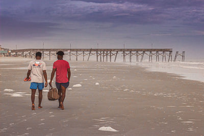 Rear view of people walking on beach