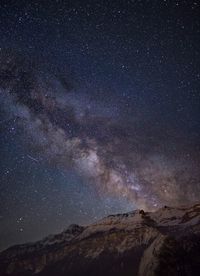 Scenic view of mountains against sky at night