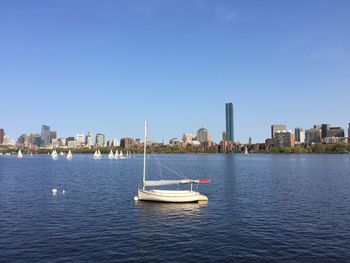 Boats in sea with cityscape in background
