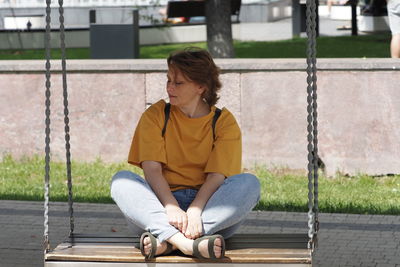 Portrait of a woman. a girl of european appearance in a yellow t-shirt is resting in the park in