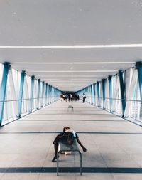 Boy sleeping on bench under covered bridge