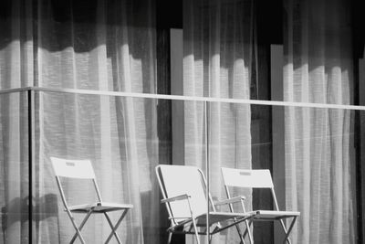 Empty chairs and tables in window