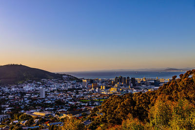 High angle view of townscape by sea against clear sky