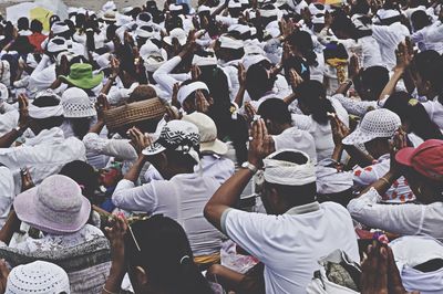 Crowd with hands clasped praying together