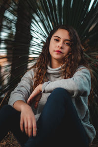 Portrait of young woman sitting outdoors