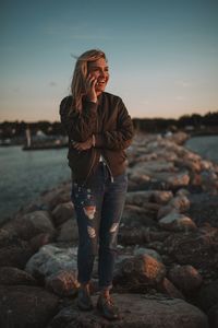 Smiling woman talking on mobile phone at beach