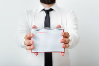 Midsection of man holding ice cream against white background