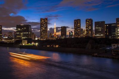 Illuminated buildings in city against sky at night