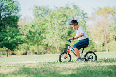 Side view of boy riding bicycle on grass