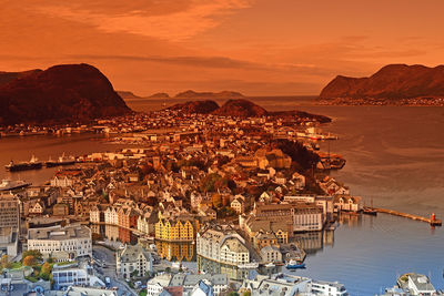 Aerial view of buildings in city during sunset