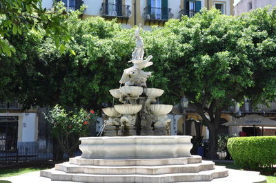 Statue against trees and building