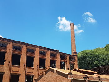 Low angle view of factory against blue sky