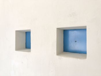 Blue windows on white wall
