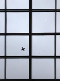 Full frame shot of airplane flying against glass window