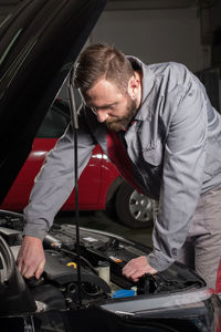 Male mechanic repairing car at auto repair shop