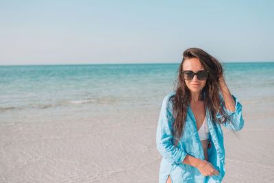 Portrait of young man wearing sunglasses on beach