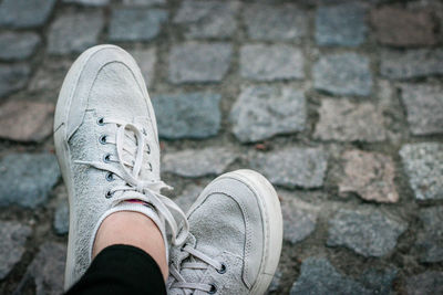 Low section of person on cobblestone footpath