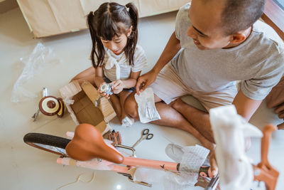 High angle view of mother and daughter sitting on floor