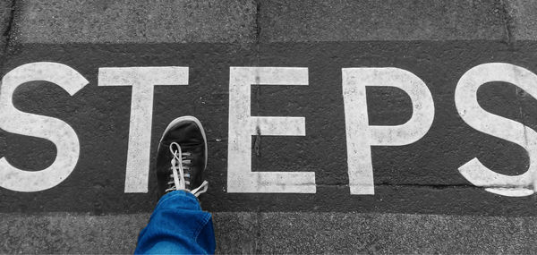 Low section of person standing on road