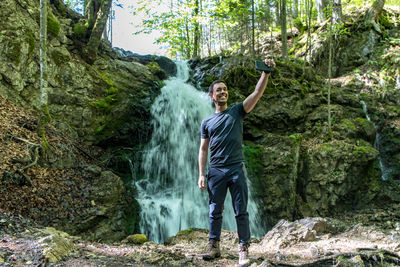 Portrait of man standing on rocks in forest