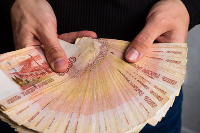 Close-up hands hold a wad of russian money five thousand bills.