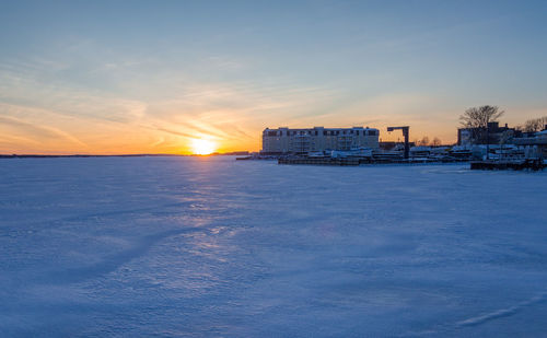 Scenic view of sea by building against sky during sunset