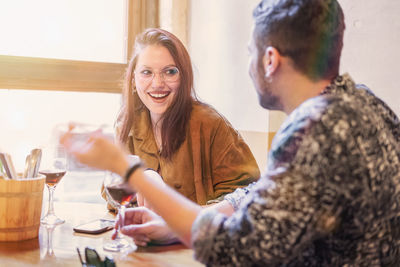 Happy young woman sitting on table