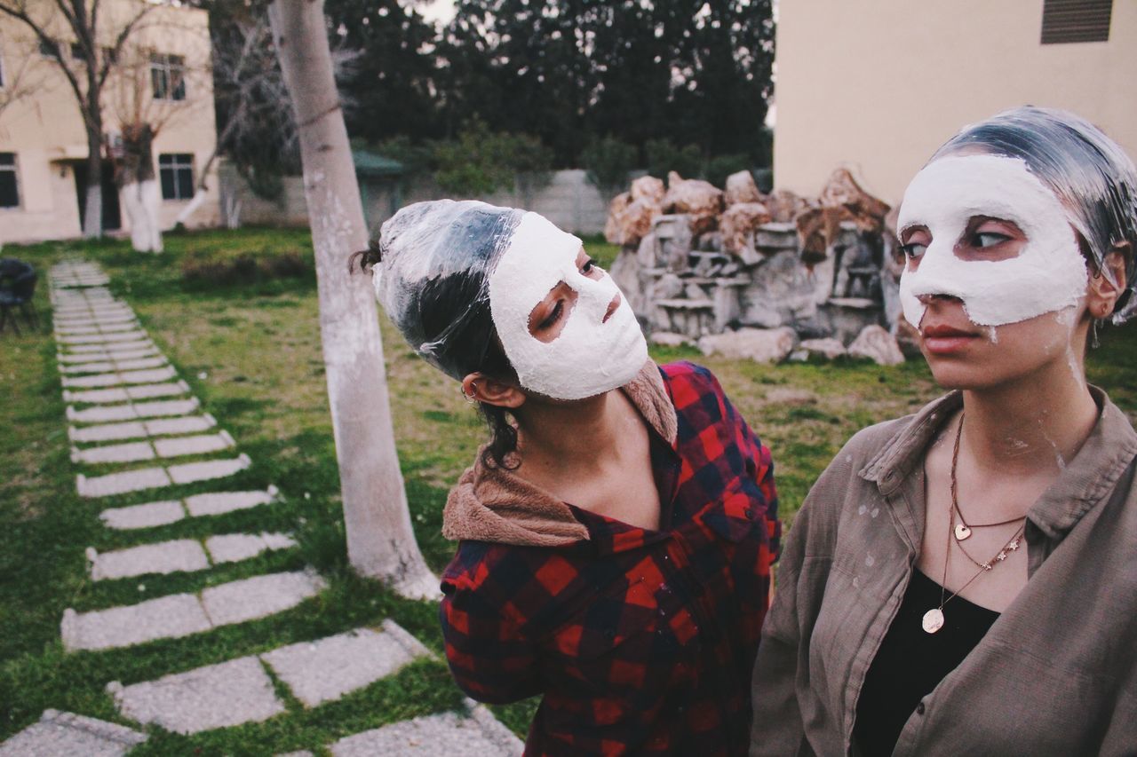 PORTRAIT OF MAN AND WOMAN STANDING AGAINST PLANTS