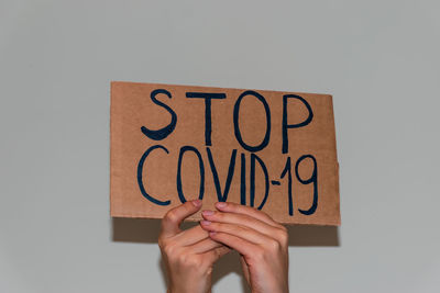 Close-up of hand holding text against white background