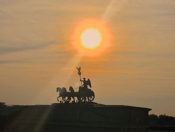 Silhouette of horse cart at sunset