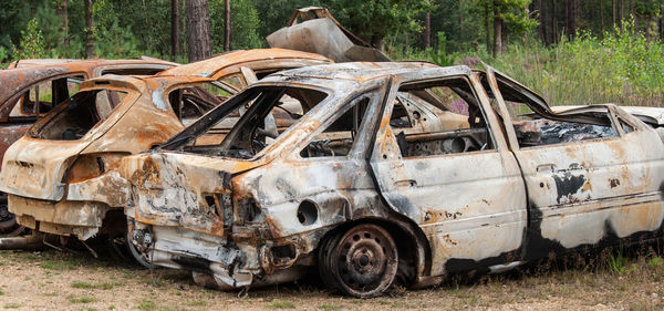 Rusty damaged cars on field