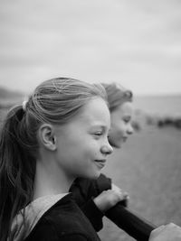 Siblings at beach against sky