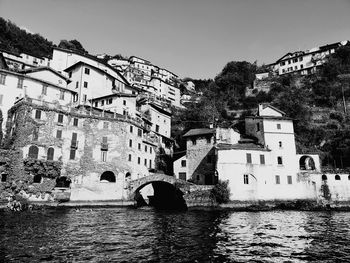 Arch bridge over river against buildings in city