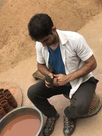 High angle view of young man sitting outdoors