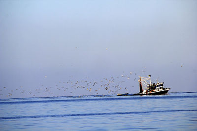 Ship sailing in sea against sky