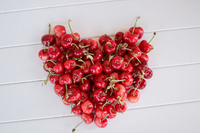 Directly above shot of cherries in heart shape on table
