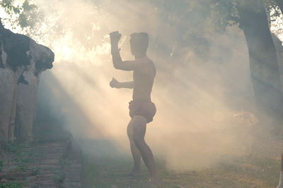 Side view of man photographing during foggy weather