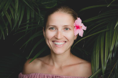 Portrait of smiling woman by plants