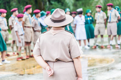 Rear view of people standing against blurred background