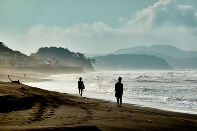 People on beach against sky