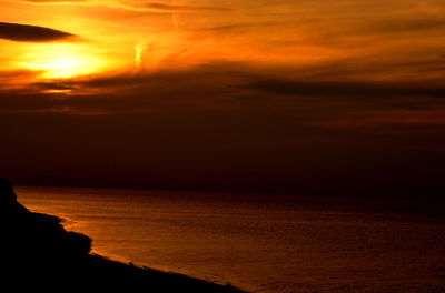 Scenic view of sea against orange sky