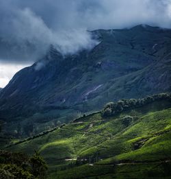 Rain clouds looming over mountain ranges with tea plantation below