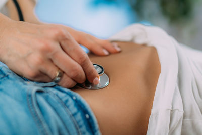 Pediatrician gastroenterologist doing abdominal examination with stethoscope