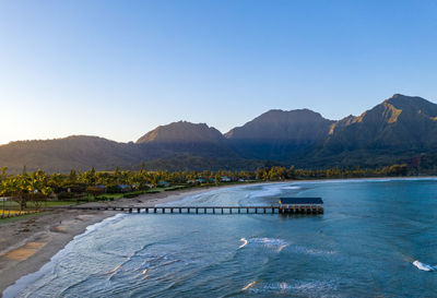 Aerial panoramic image at sunrise off the coast over hanalei bay and pier on kauai