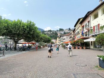 People walking on street amidst buildings in city