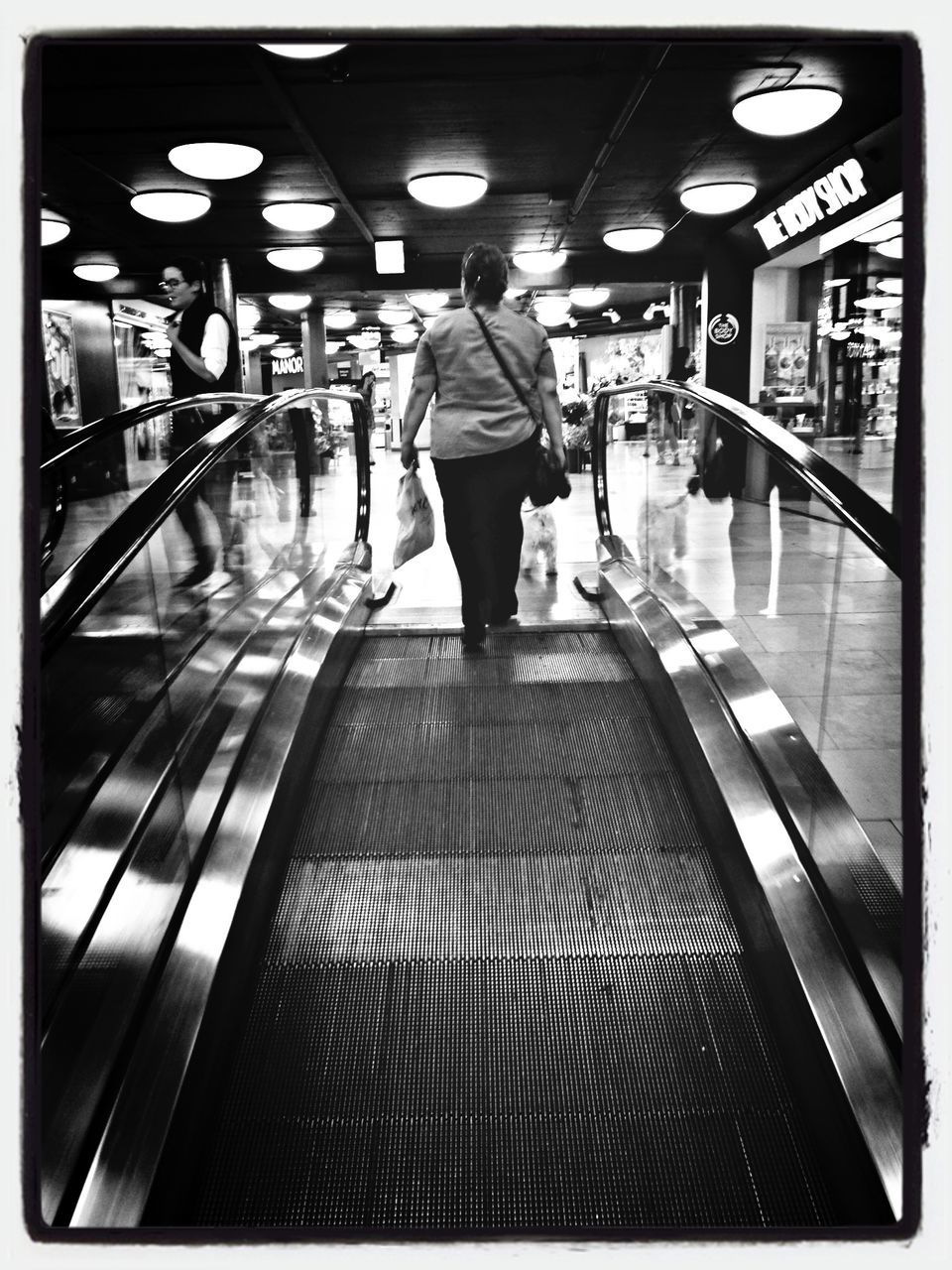 transfer print, indoors, men, auto post production filter, lifestyles, rear view, walking, illuminated, person, leisure activity, full length, ceiling, standing, city life, travel, lighting equipment, incidental people, subway station